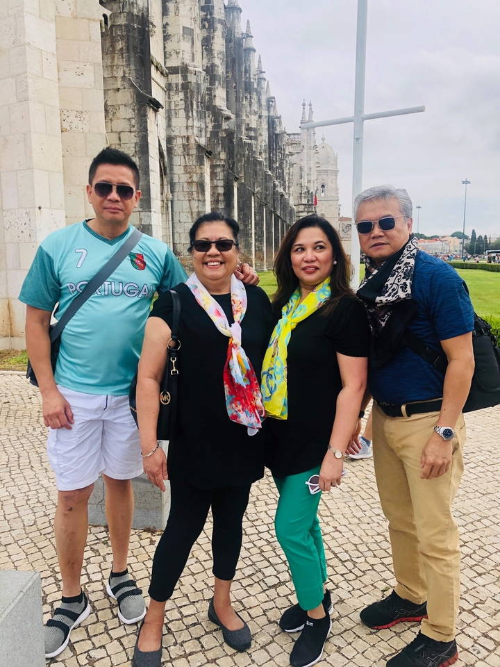 Groupe de personnes souriantes, certaines portant des vêtements aux couleurs du Portugal.