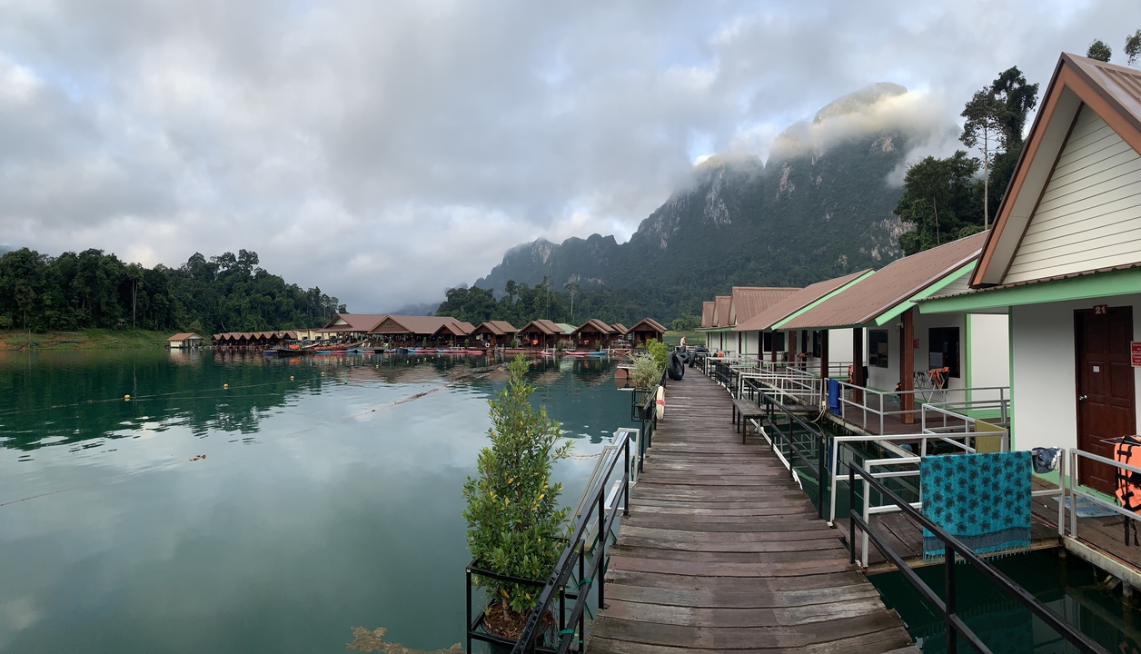 Row of lakefront bungalows in a serene mountainous setting.