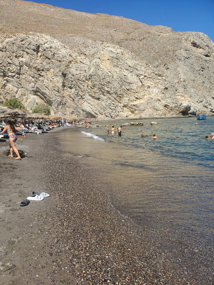 Des gens qui profitent d'une plage près de falaises rocheuses.