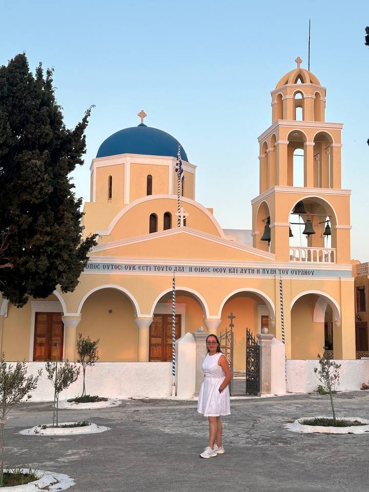 Personne debout devant une église avec un dôme bleu.