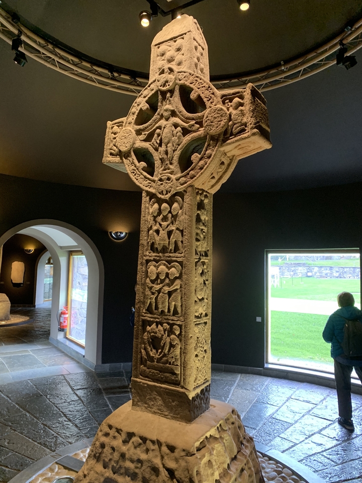 Ancienne croix de pierre dans un cadre muséal.