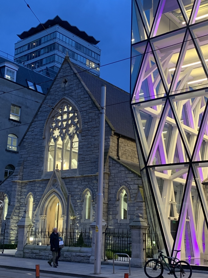 Église historique avec bâtiment moderne en verre.
