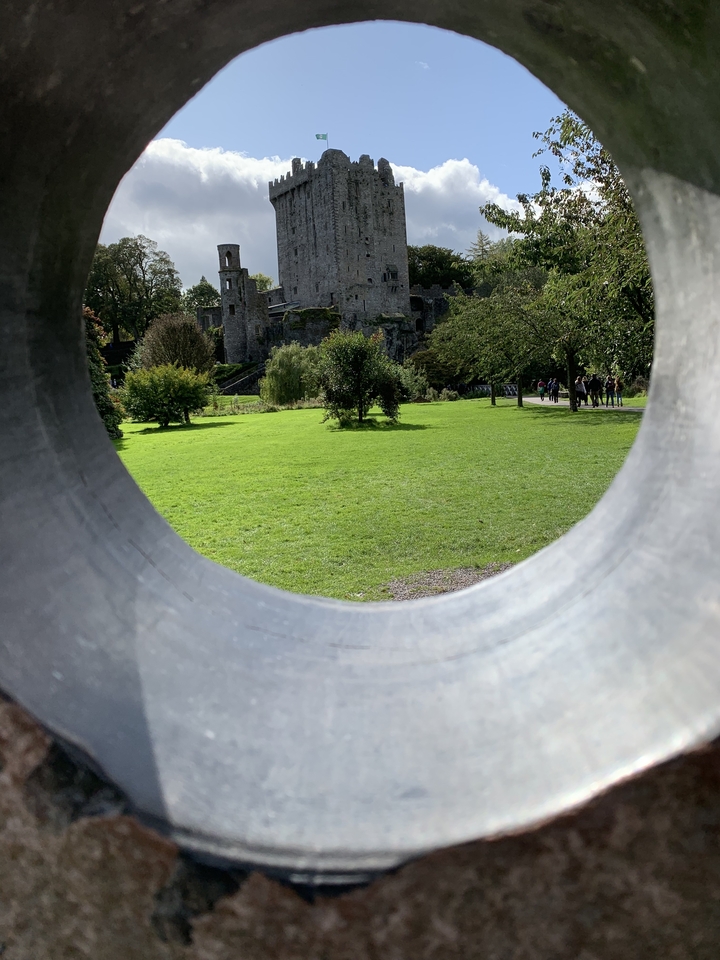 Vue paysagère à travers un cadre de pierre circulaire.