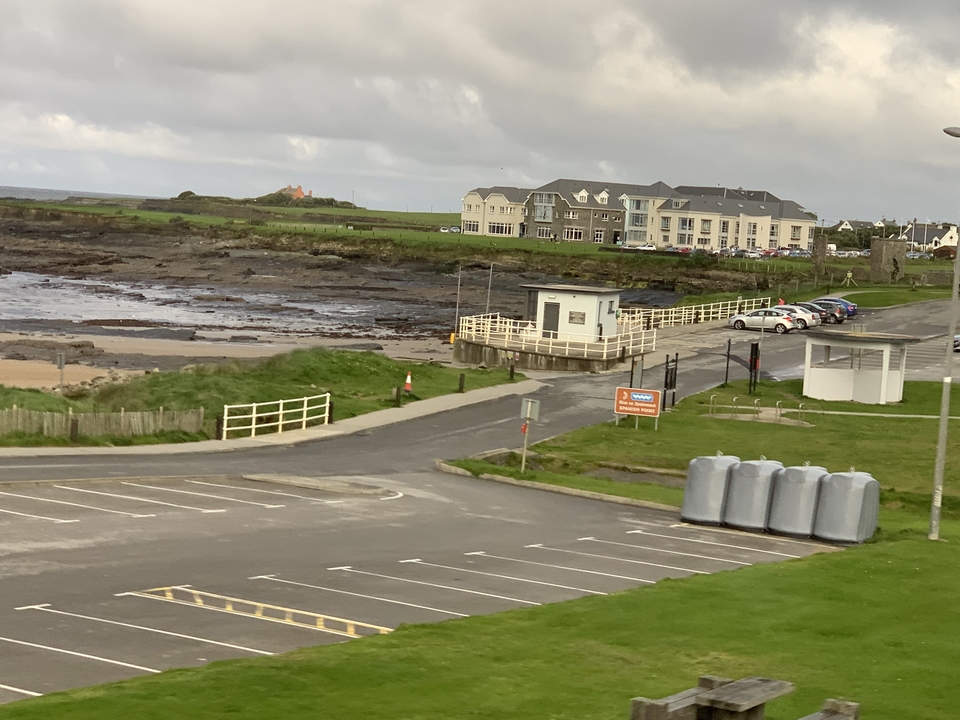 Zone côtière avec bâtiments et rivage rocheux.
