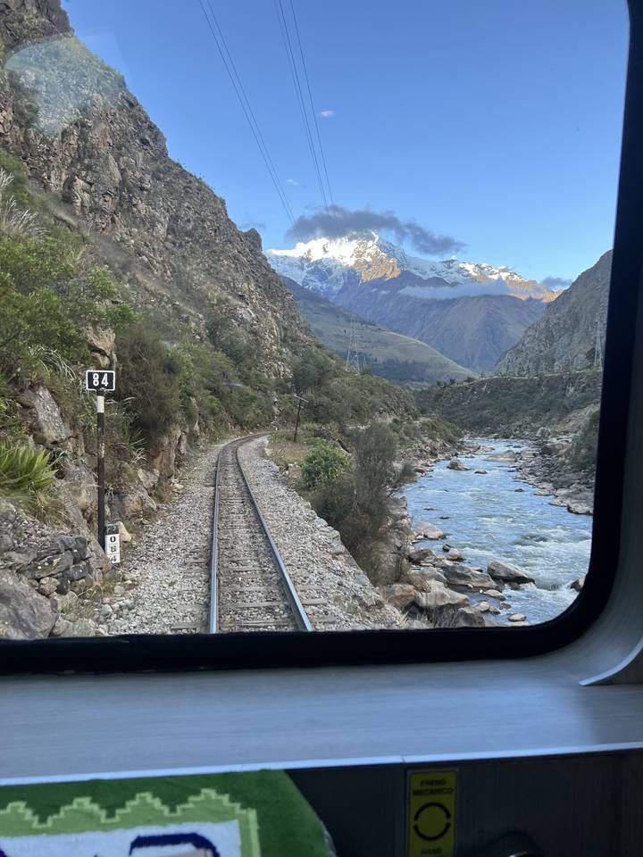 Vue panoramique des montagnes et d'une rivière vue depuis la fenêtre d'un train.