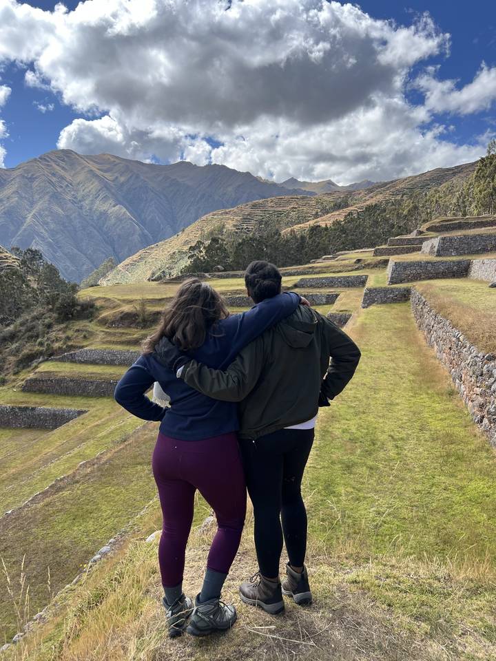 Deux personnes debout sur une colline avec des champs en terrasses.