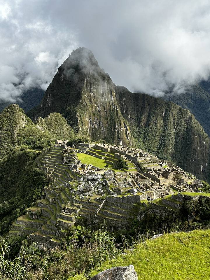 Ruines du Machu Picchu sur une montagne entourée de verdure.