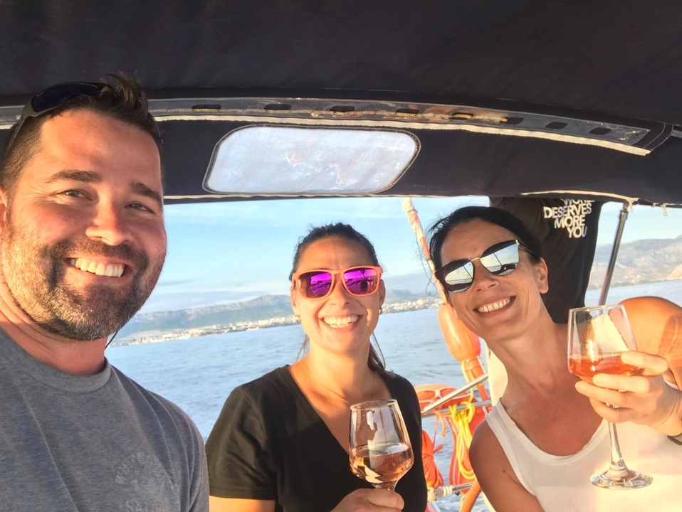 Trois personnes savourant des boissons sur un bateau.
