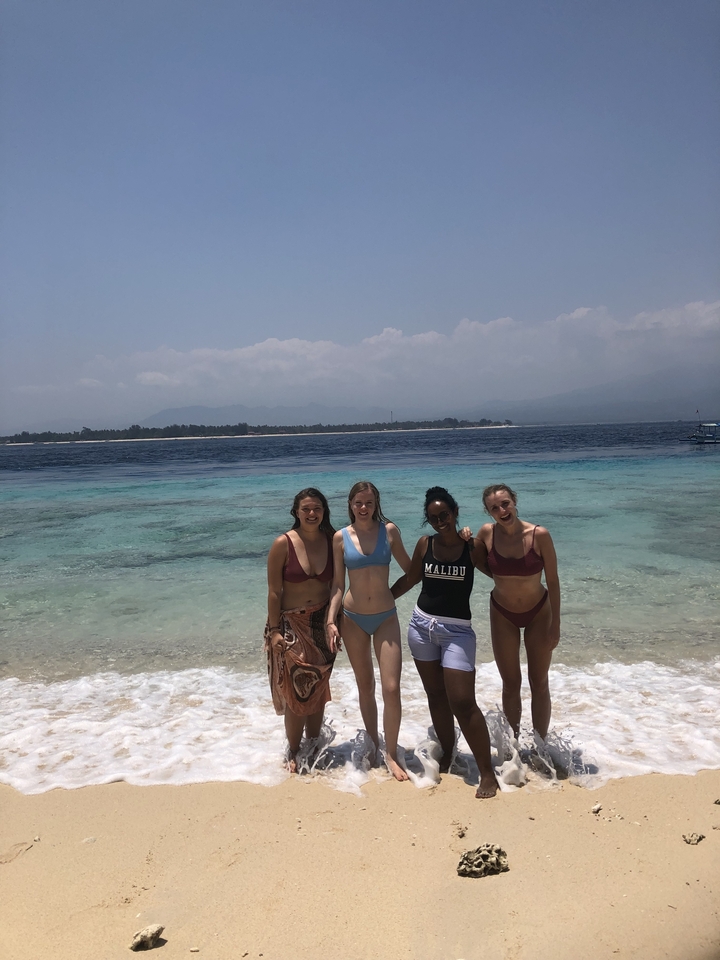 Quatre femmes debout dans l'océan jusqu'aux genoux.