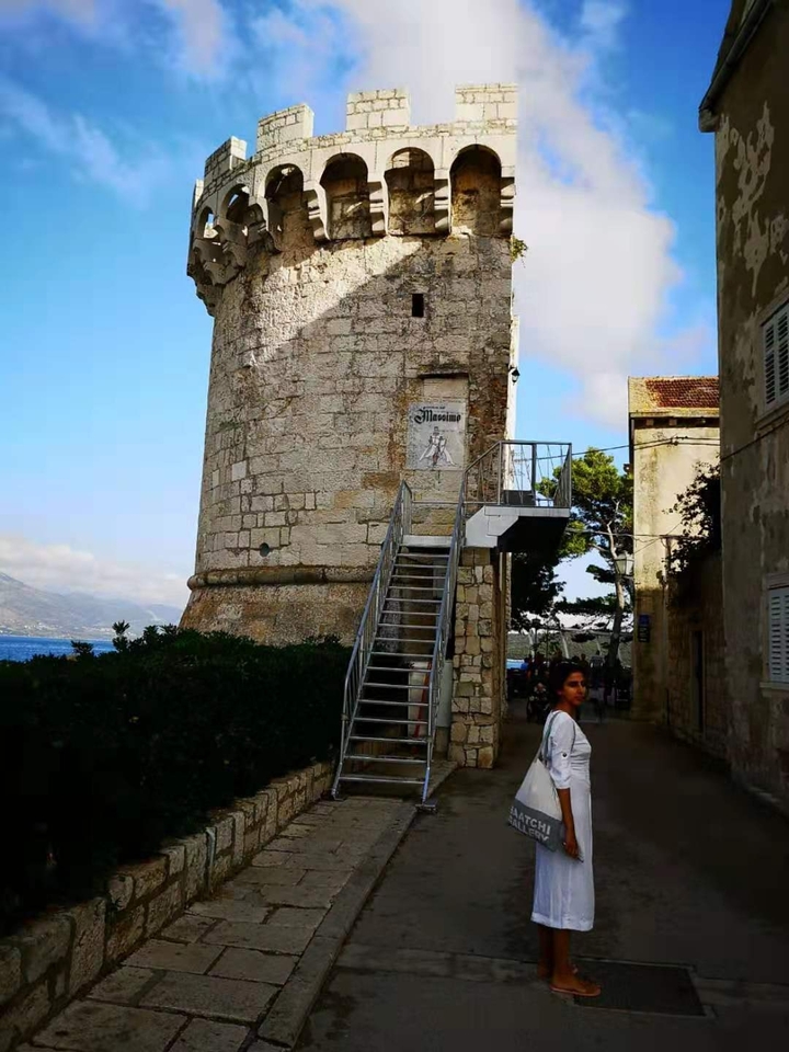 Tour de pierre sur la côte avec un escalier et une personne.