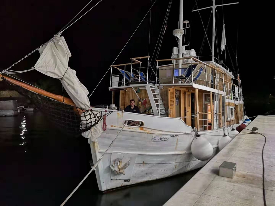 Un navire en bois amarré à un quai pendant la nuit.