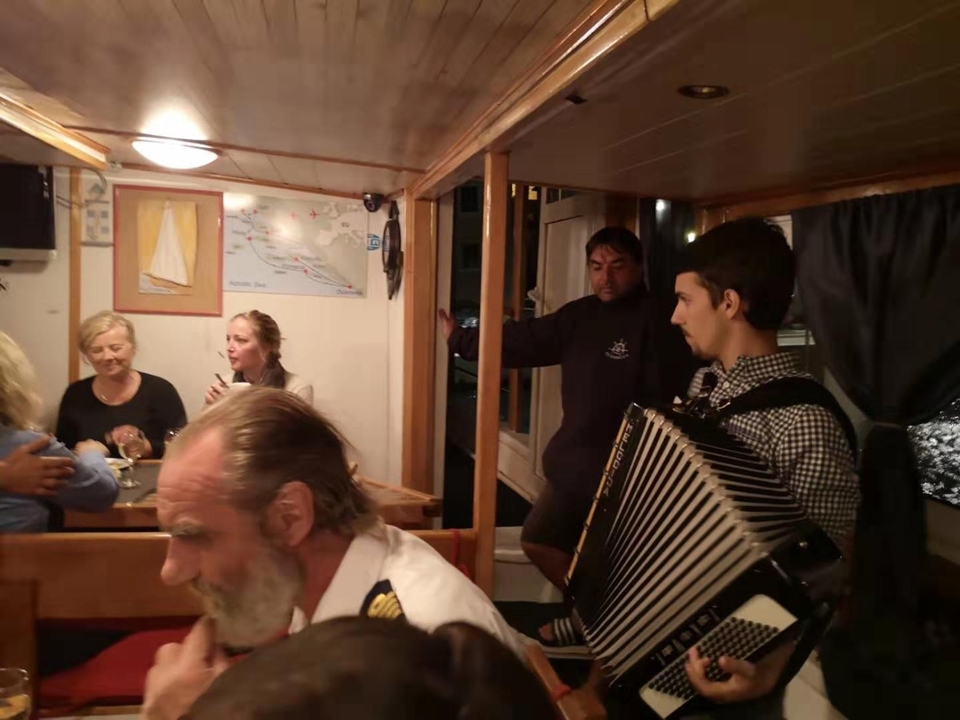 Des gens dans un bateau avec un joueur d'accordéon.