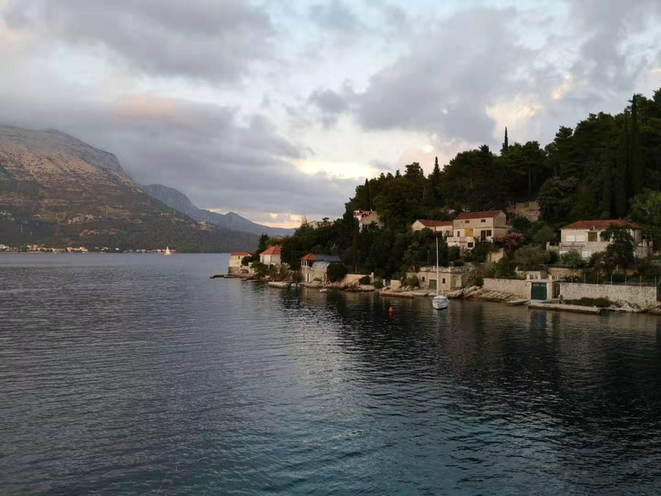 Vue côtière pittoresque avec des bâtiments au bord de la mer au crépuscule.