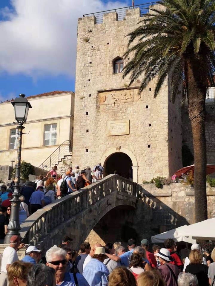 Des touristes montant les escaliers vers un bâtiment historique.