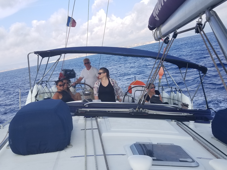 Des personnes naviguant sur un yacht avec une vue dégagée sur la mer.