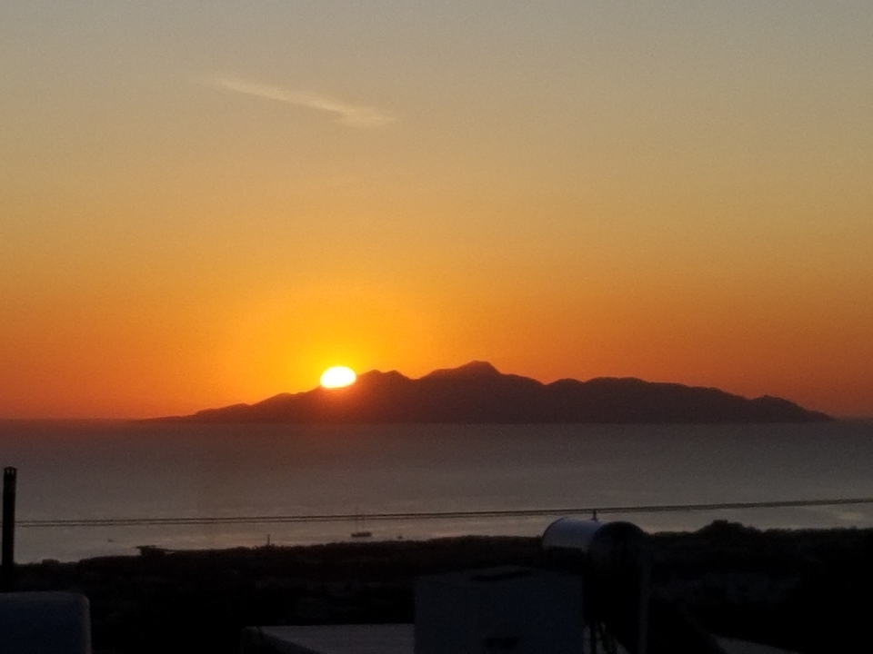 Soleil couchant derrière les montagnes au-dessus de la mer.