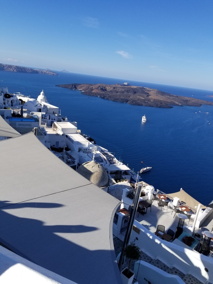 Vue aérienne de bâtiments blancs sur des falaises surplombant la mer.