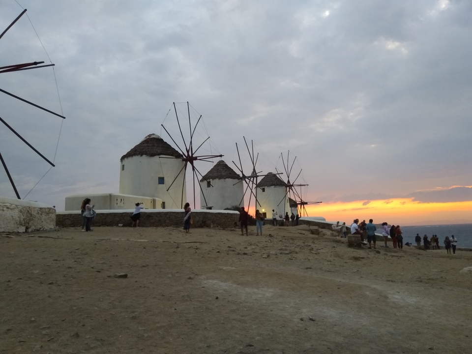 Moulins à vent avec des touristes au coucher du soleil.