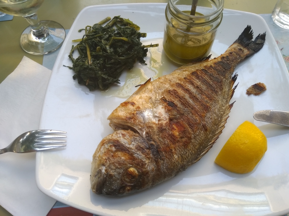 Assiette avec poisson grillé et légumes verts.