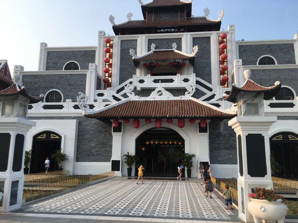 Temple asiatique traditionnel avec des lanternes et des visiteurs à l'extérieur