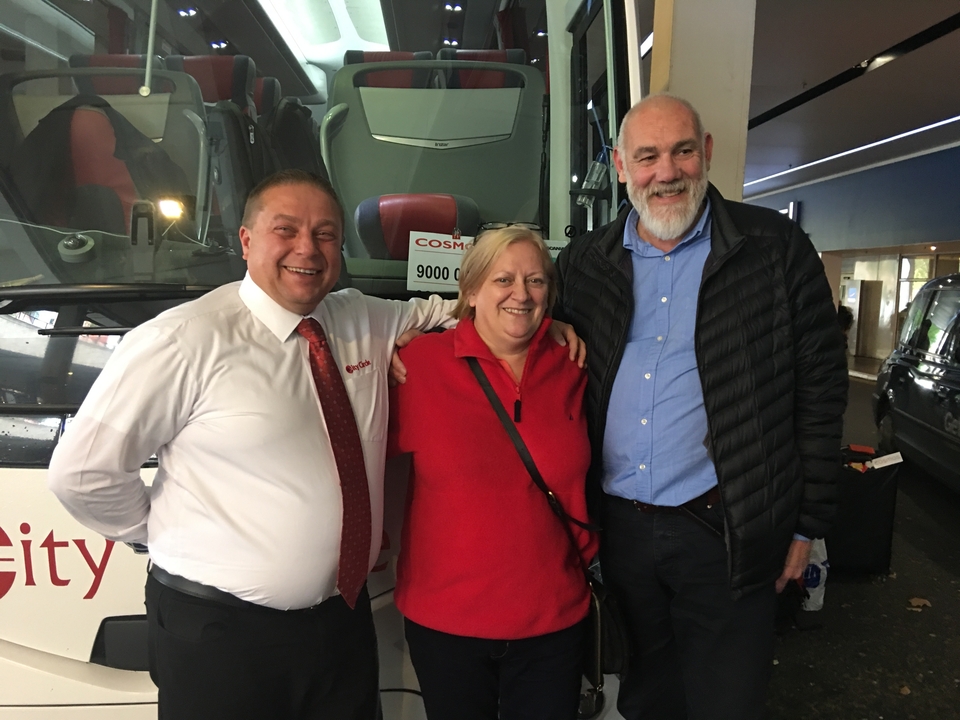 Trois personnes posant devant un bus.