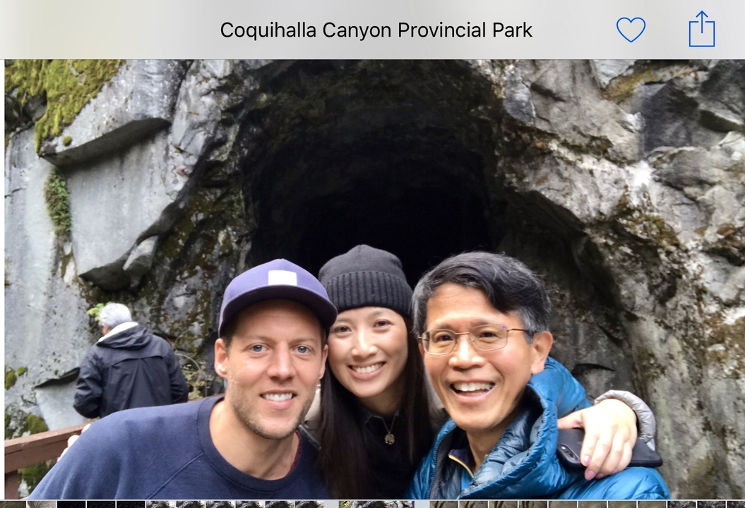 Un groupe posant devant l'entrée d'une grotte taillée dans une paroi rocheuse.