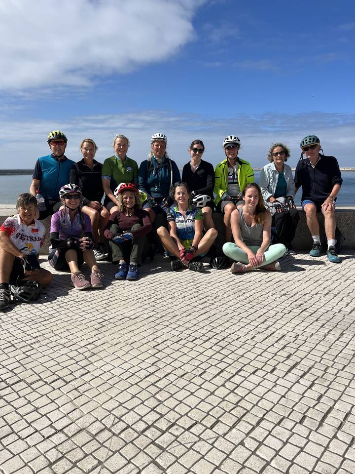 Groupe de personnes assises en cercle à l'extérieur.