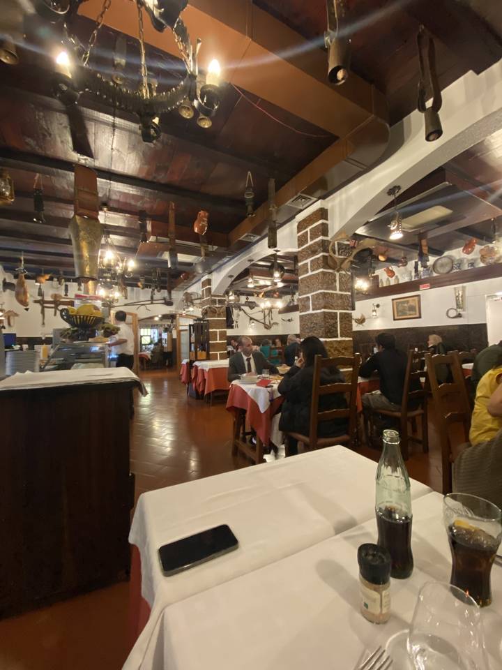 Intérieur de restaurant avec tables et convives.