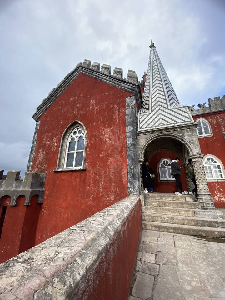 Des visiteurs dans un bâtiment rouge historique.