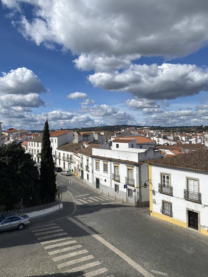 Rues d'une ville avec des bâtiments traditionnels sous un ciel majoritairement nuageux.