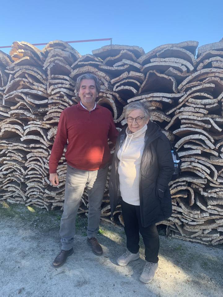 Deux personnes debout devant des bouchons empilés.