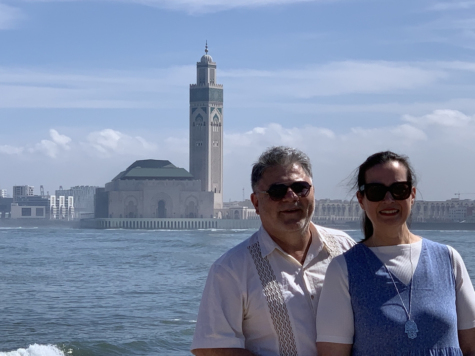 Couple posant devant une mosquée au bord de l'eau.