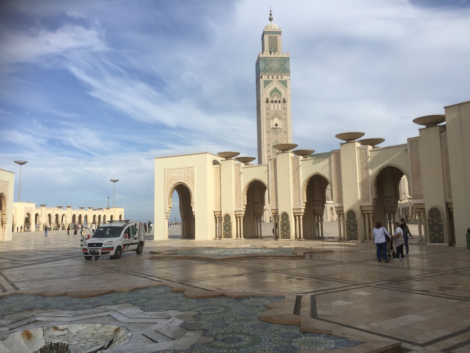 Une grande cour intérieure comprenant une mosquée avec des arches et une place ouverte.