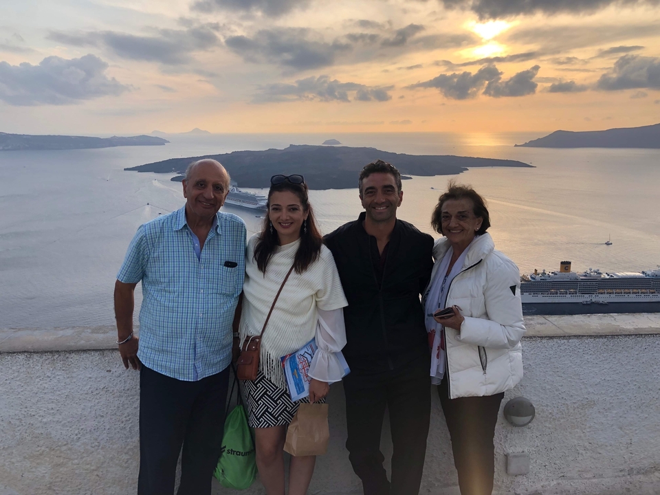 Groupe debout contre un coucher de soleil en arrière-plan près de la mer avec vue sur la caldeira de Santorin.