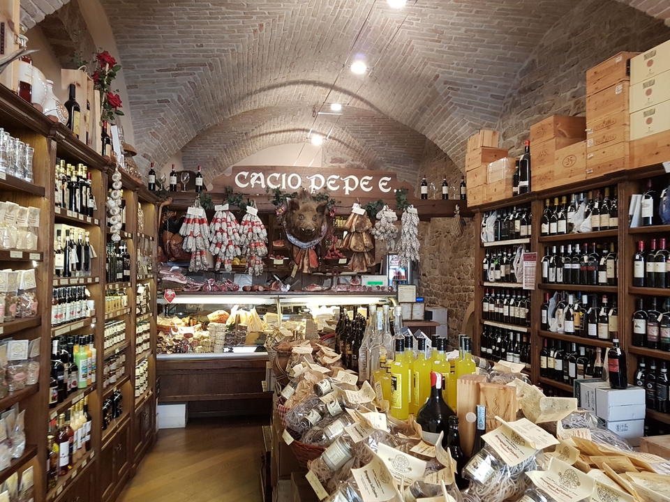 Magasin italien rempli de vins et de produits de charcuterie.