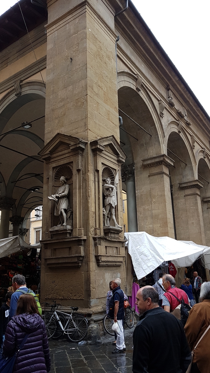 Statues sur une colonne sous une structure voûtée.