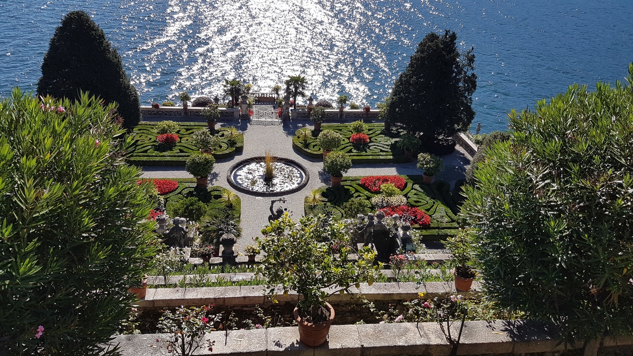 Beau jardin donnant sur un plan d'eau avec des motifs ornementaux.