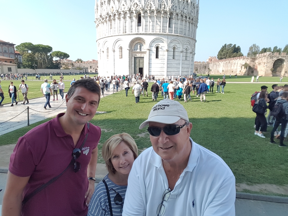 Trois personnes avec la tour de Pise en arrière-plan.