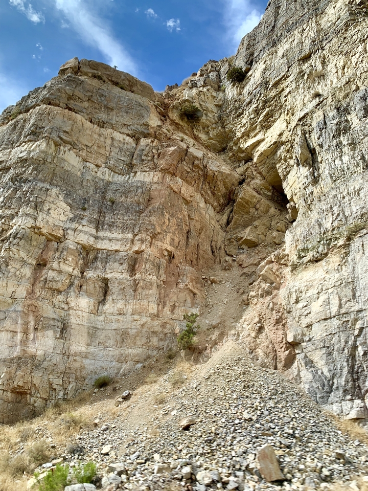 Paroi rocheuse escarpée avec des striations visibles.