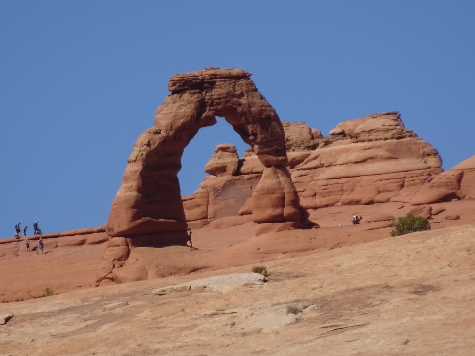 Delicate Arch dans le parc national des Arches avec des personnes à proximité.