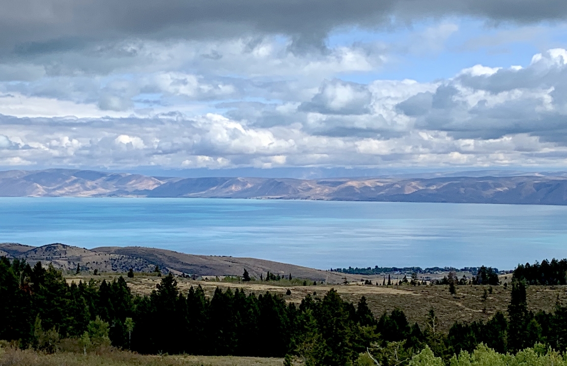 Grand lac avec des montagnes et des nuages en arrière-plan.