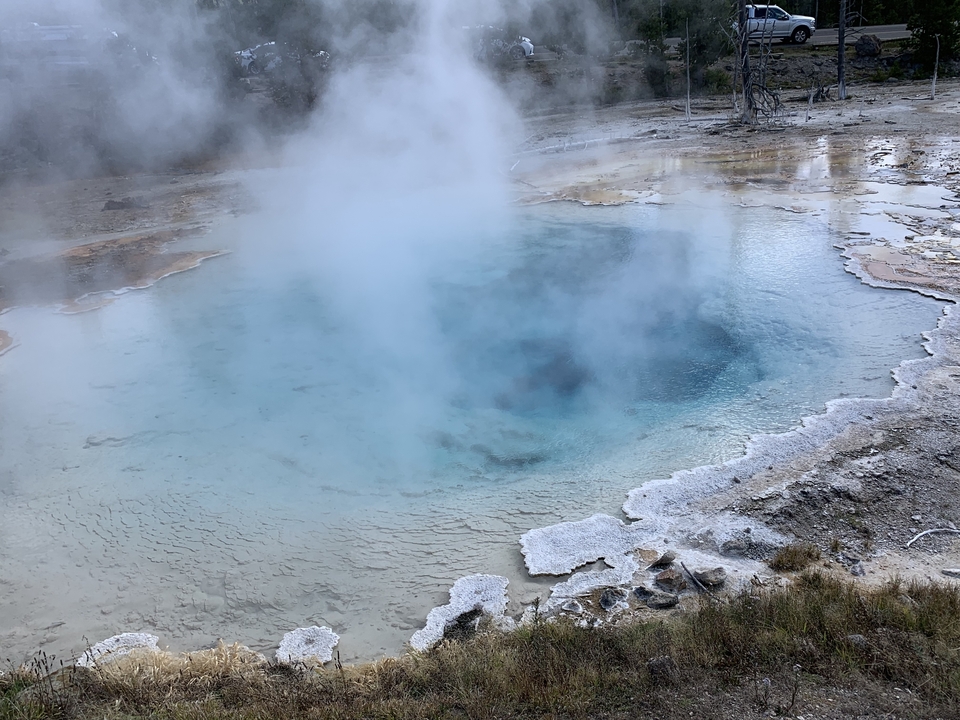 Source géothermale avec vapeur s'élevant dans le parc national de Yellowstone.
