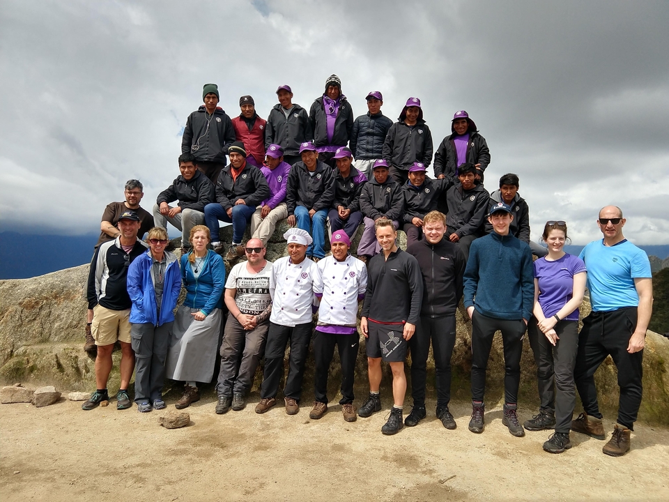 Un grand groupe de personnes posant dans une région montagneuse.