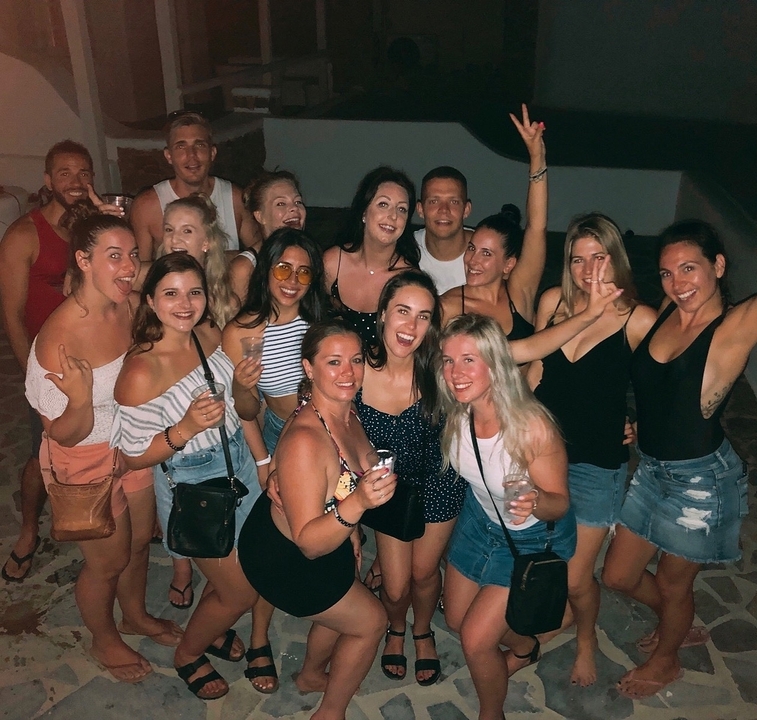 Group of people posing for a photo at night.