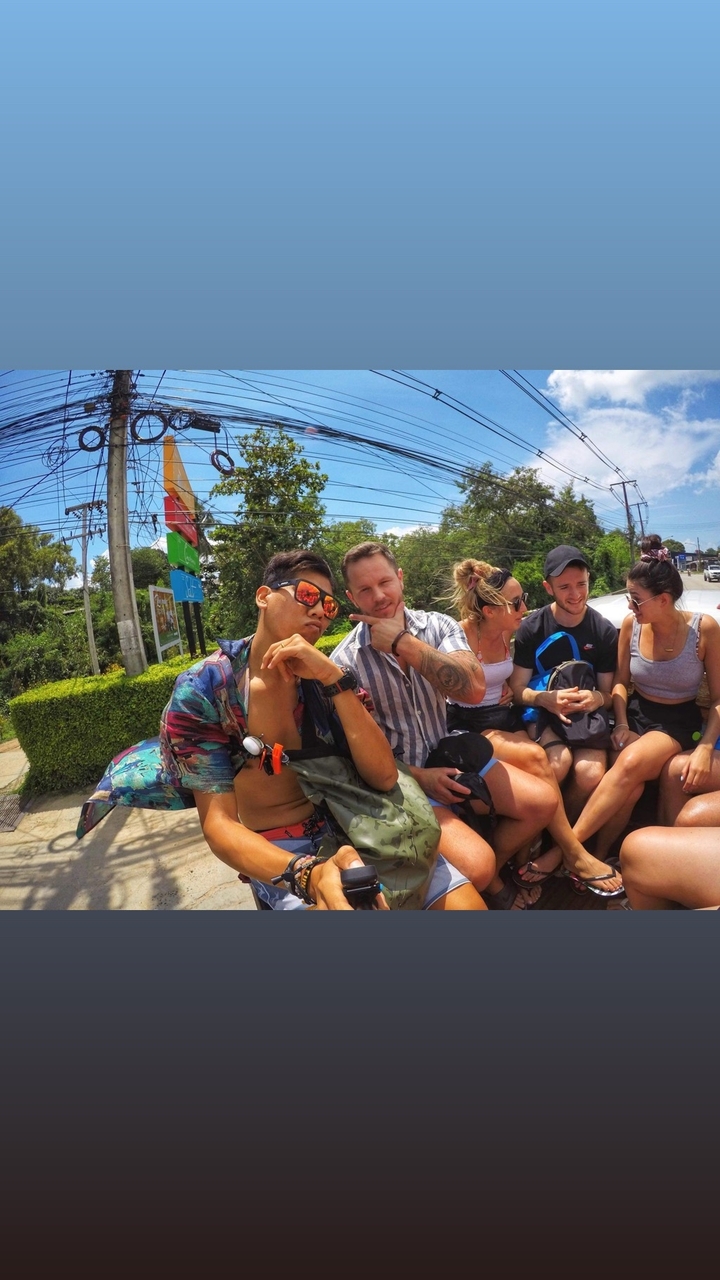 Groupe d'amis s'amusant en voyageant à l'arrière d'un véhicule.