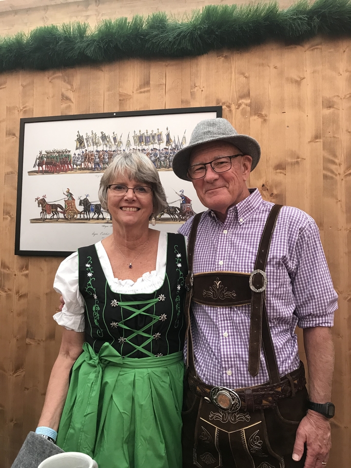 Couple âgé en vêtements traditionnels bavarois posant à l'intérieur.