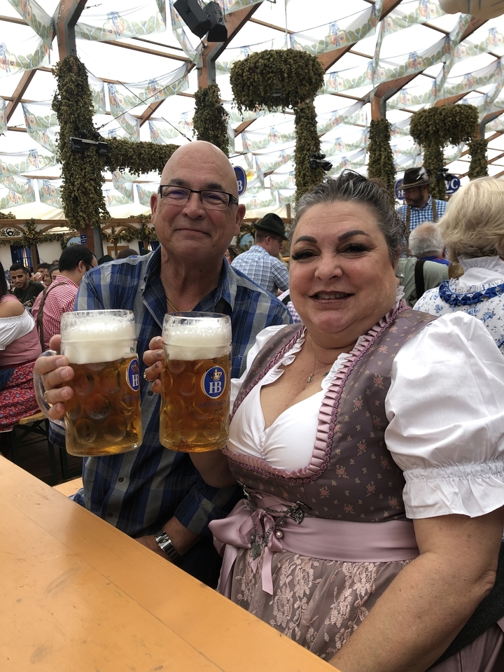 Homme et femme tenant de grandes chopes de bière lors d'un festival.