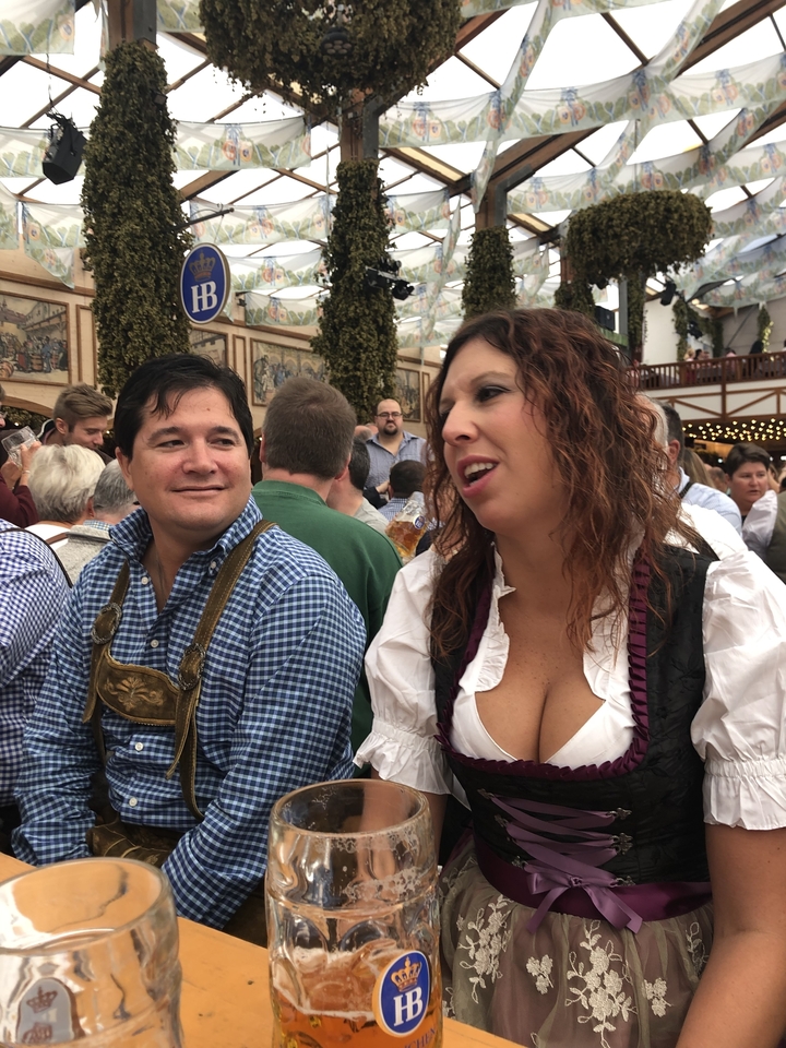 Un couple assis à une table avec des gens en arrière-plan.