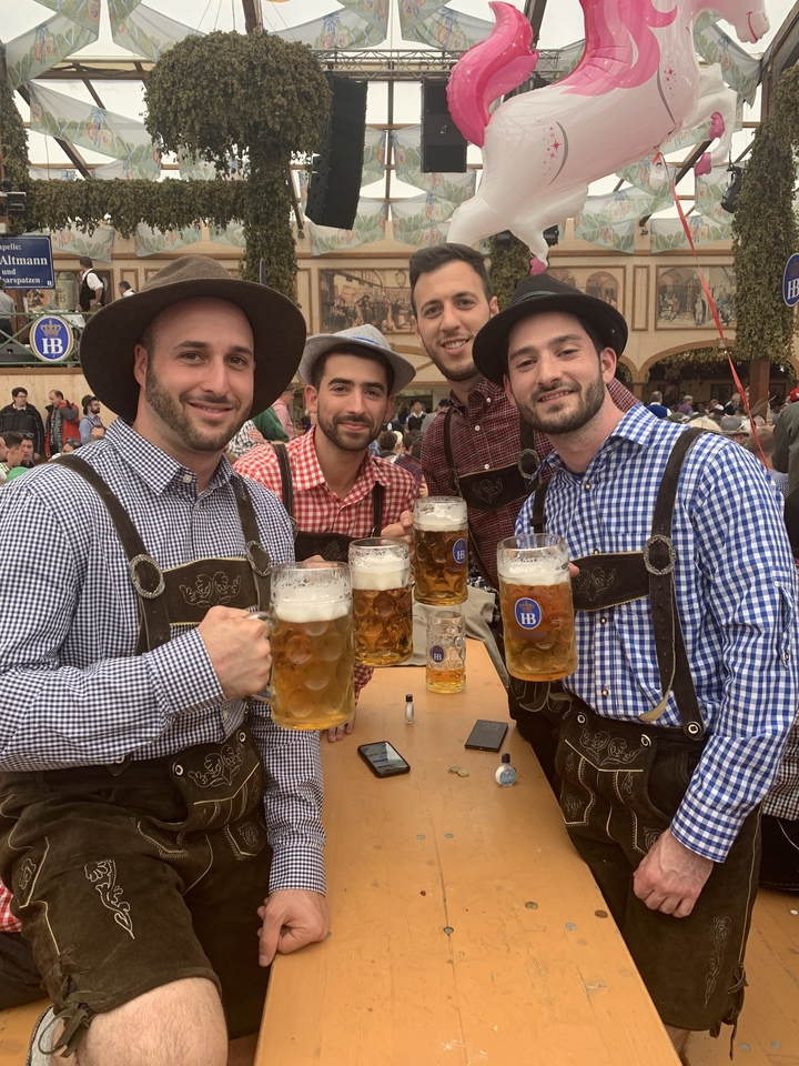Un groupe d'hommes en tenue traditionnelle tenant des chopes de bière.