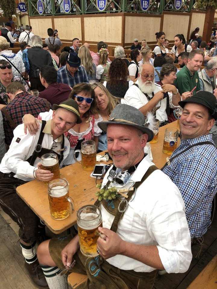 Groupe de personnes savourant des bières en tenue traditionnelle.